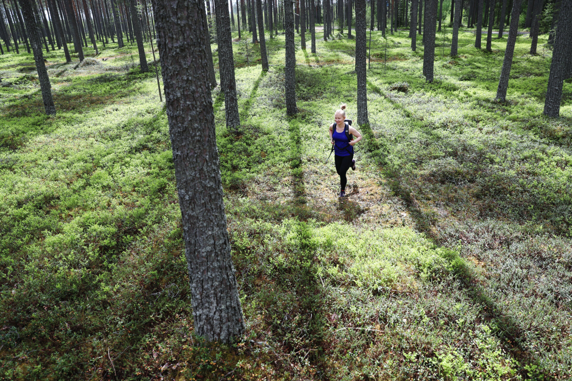 Nainen patikoimassa Oulujärven rauhallisessa metsämaisemassa – luontoelämyksiä askel kerrallaan.