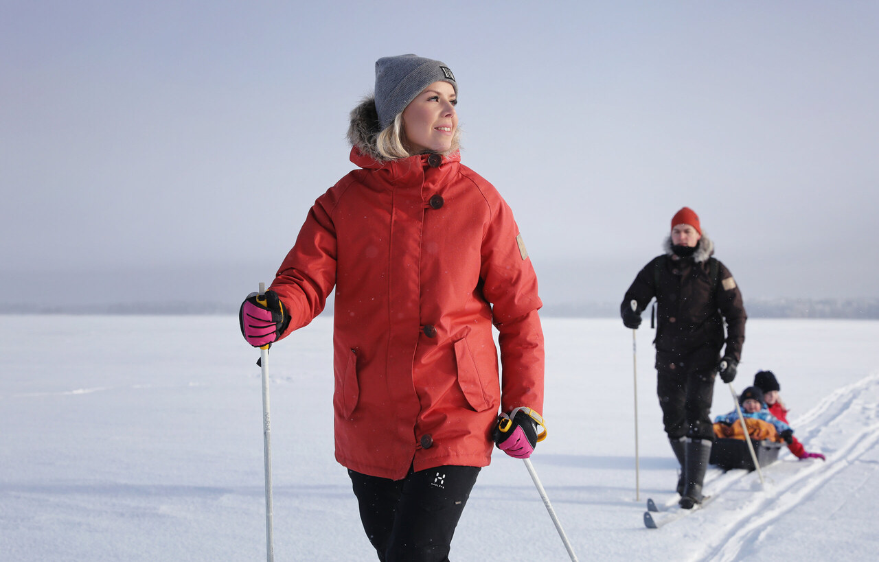 Perhe nauttii yhteisestä hiihtoretkestä Oulujärven jäällä talvisessa luonnossa.